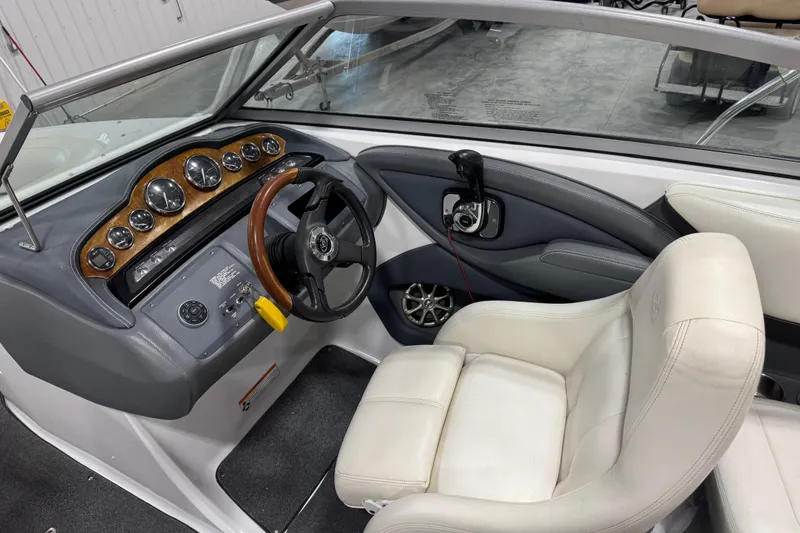 Slide: The Image of Interior of a 2008 Cobalt 232 boat featuring steering wheel and dashboard controls. - 8