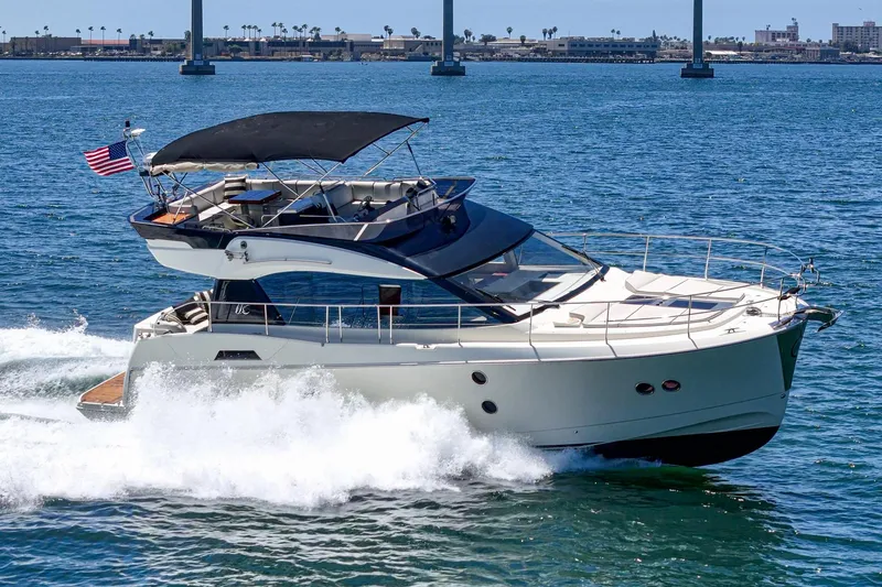 Slide: The Image of 2017 Monte Carlo MC5S yacht cruising on open water with bridge in background. - 10