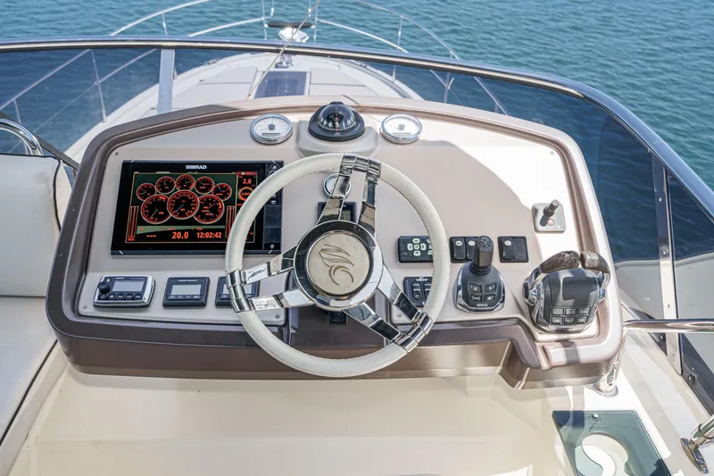 Slide: The Image of 2017 Monte Carlo MC5S yacht helm with steering wheel, navigation controls, and digital display. - 23
