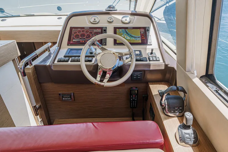 Slide: The Image of Cockpit of 2017 Monte Carlo MC5S yacht with modern navigation controls and red seating. - 44