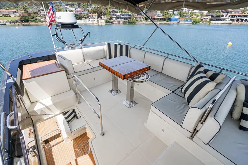 Slide: The Image of Luxurious 2017 Monte Carlo MC5S yacht deck with seating and table, overlooking serene waters. - 24