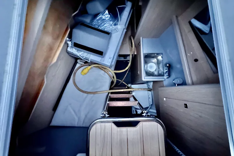 Slide: The Image of Interior view of 2021 Beneteau Oceanis 55.1 sailboat, featuring compact storage and a small sink. - 13
