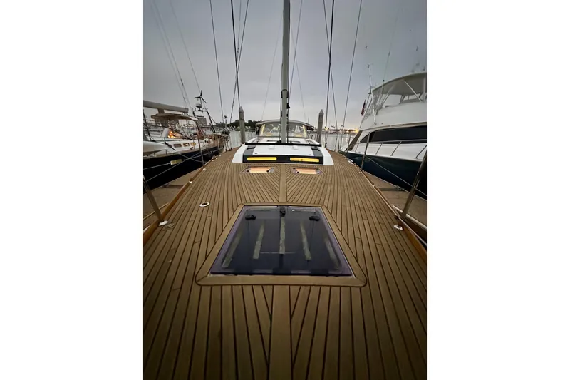Slide: The Image of 2021 Beneteau Oceanis 55.1 yacht deck with sleek wooden finish, docked at marina. - 15
