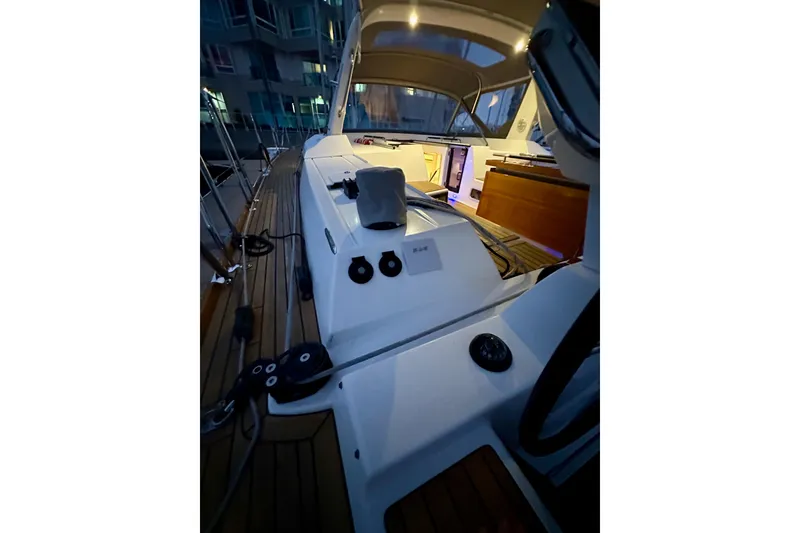 Slide: The Image of 2021 Beneteau Oceanis 55.1 yacht deck at night, illuminated interior, modern design. - 25