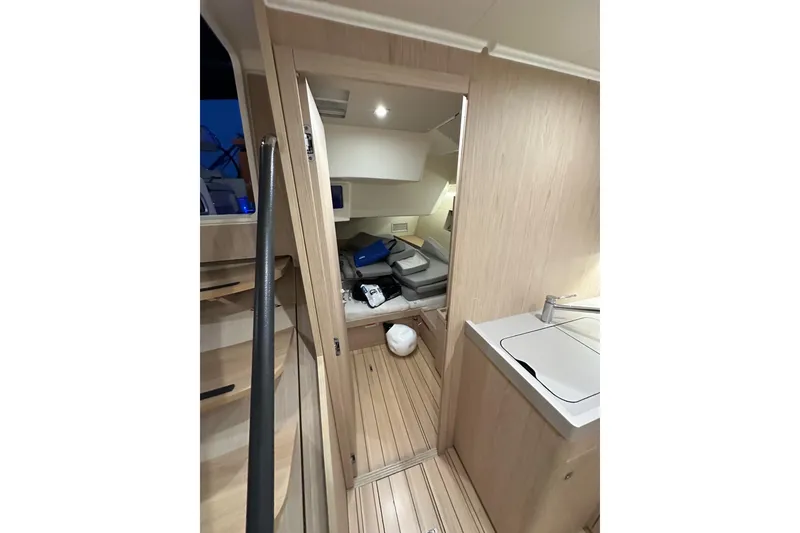 Slide: The Image of Interior of 2021 Beneteau Oceanis 55.1 yacht, featuring modern wood finish and compact design. - 46