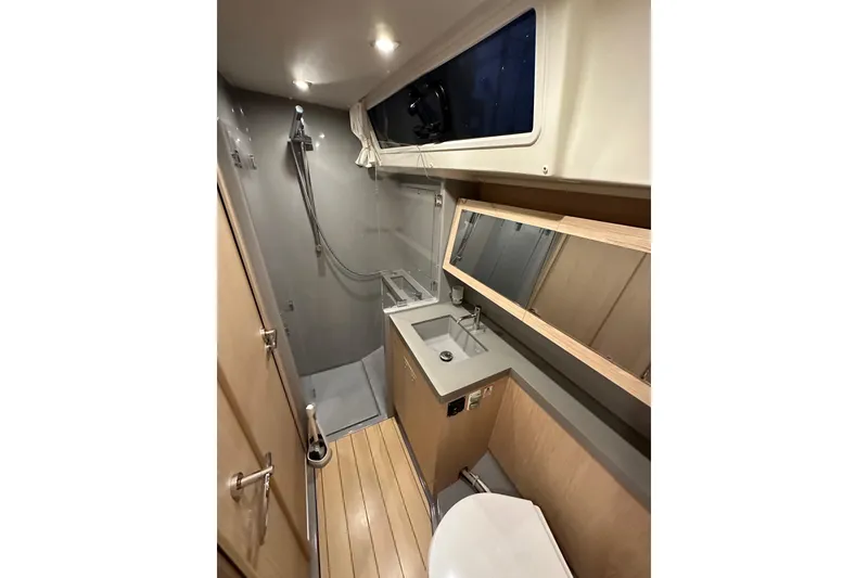 Slide: The Image of Modern bathroom in 2021 Beneteau Oceanis 55.1 yacht with shower, sink, and toilet. - 51