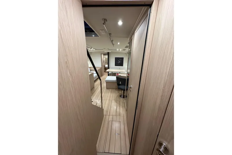 Slide: The Image of Interior view of 2021 Beneteau Oceanis 55.1 yacht, featuring modern wood finish and seating area. - 54