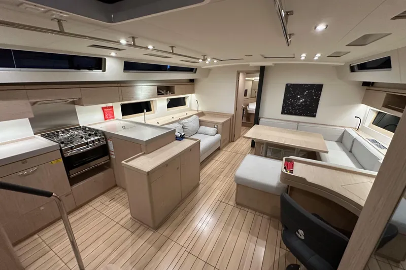 Slide: The Image of Luxurious interior of 2021 Beneteau Oceanis 55.1 yacht with modern kitchen and seating area. - 55