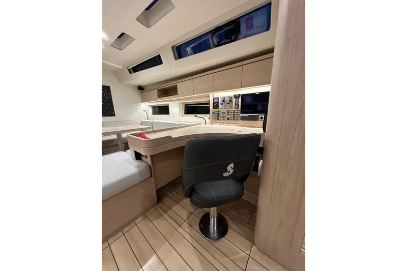 Slide: The Image of Interior of 2021 Beneteau Oceanis 55.1 yacht, featuring modern navigation station and seating. - 56