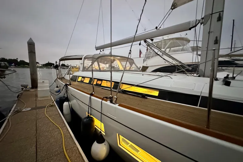 Slide: The Image of 2021 Beneteau Oceanis 55.1 yacht docked at marina during evening. - 6