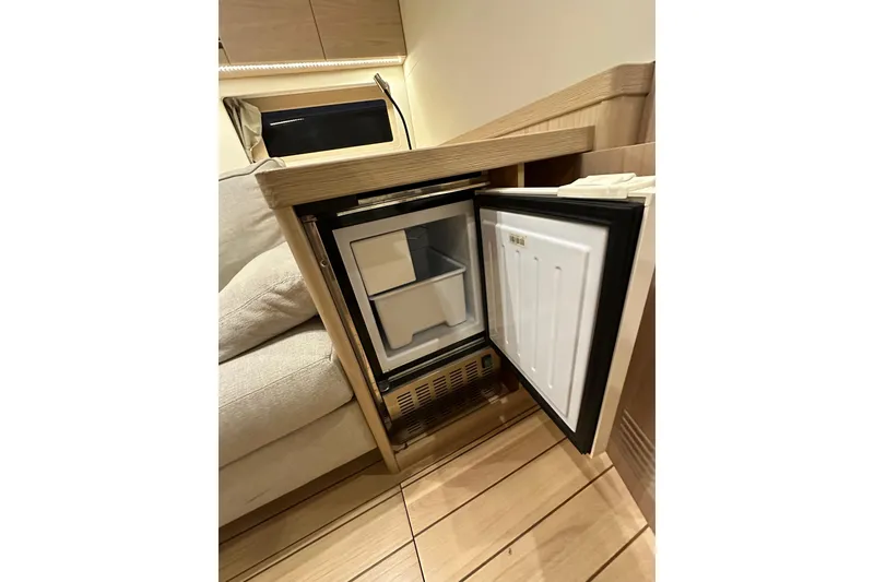 Slide: The Image of Compact refrigerator in 2021 Beneteau Oceanis 55.1 yacht interior, open door view. - 65