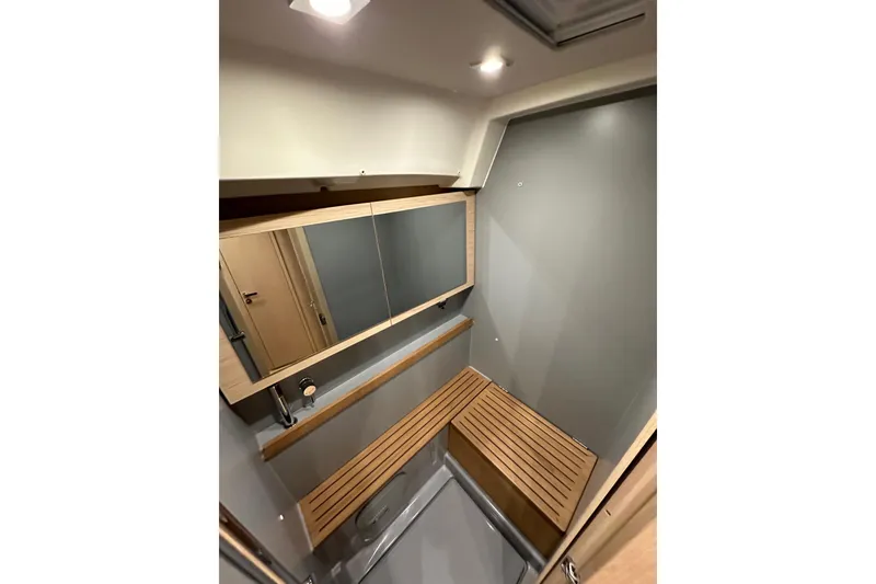 Slide: The Image of Interior of 2021 Beneteau Oceanis 55.1 yacht bathroom with wooden accents and mirror. - 70