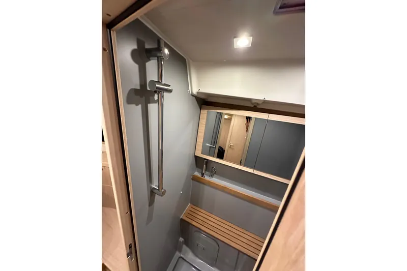 Slide: The Image of Beneteau Oceanis 55.1 2021 yacht bathroom with modern shower and wooden accents. - 71