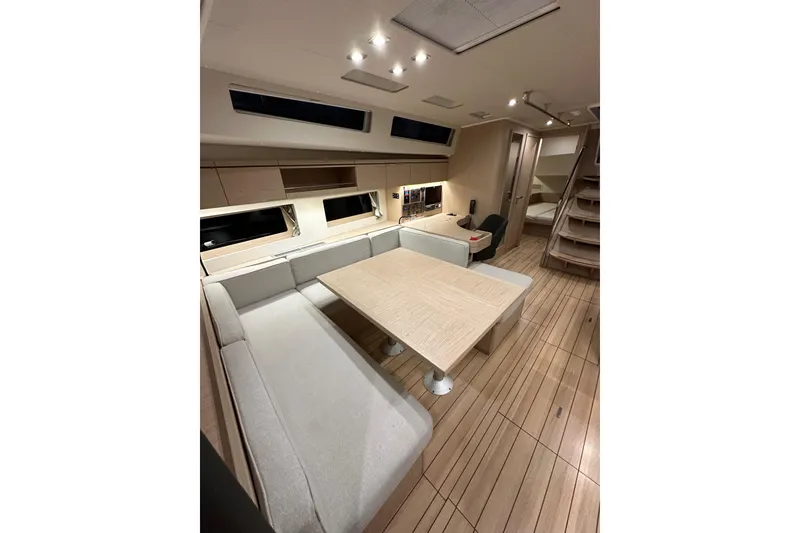 Slide: The Image of Interior of 2021 Beneteau Oceanis 55.1 yacht, featuring modern dining area and wooden flooring. - 77