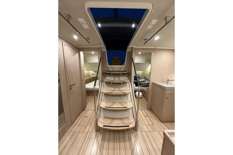 Slide: The Image of Interior of 2021 Beneteau Oceanis 55.1 yacht, featuring modern wooden staircase and elegant design. - 79