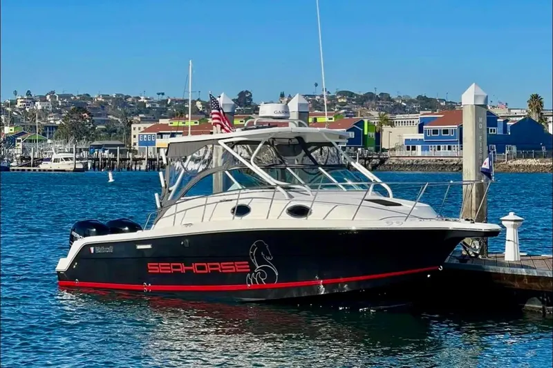 Slide: The Image of 2018 Wellcraft 290 Coastal boat docked in a marina, featuring "Seahorse" branding. - 1