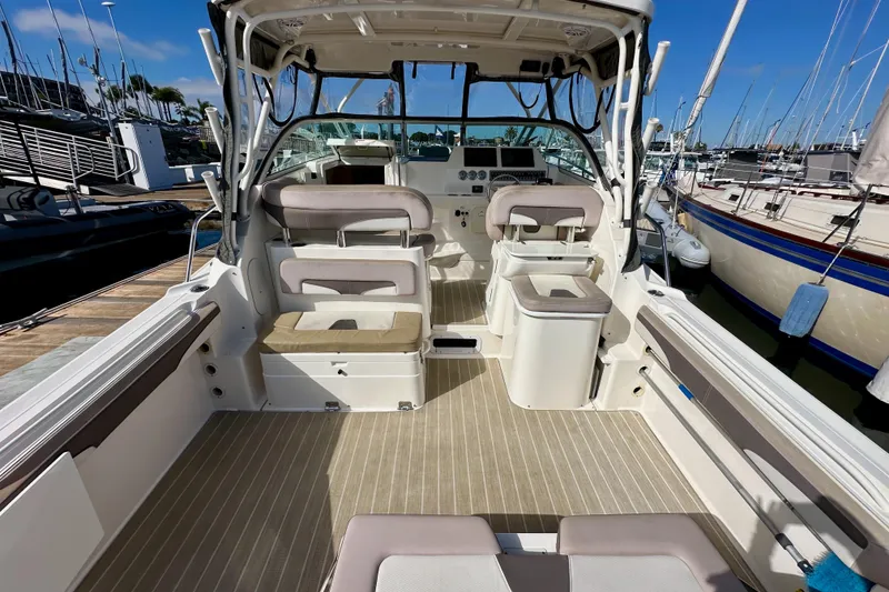 Slide: The Image of 2018 Wellcraft 290 Coastal boat interior with seating and helm, docked at marina. - 12