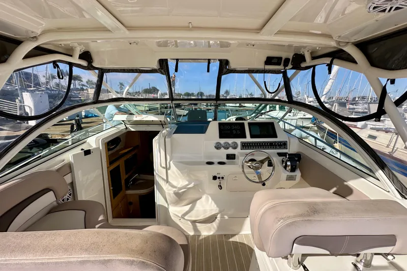 Slide: The Image of 2018 Wellcraft 290 Coastal boat interior with helm, seating, and marina view. - 18