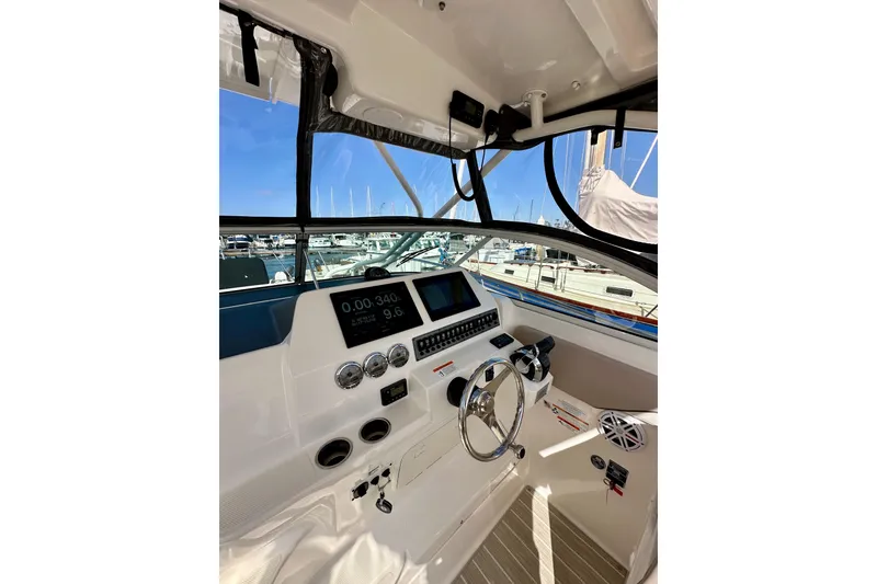 Slide: The Image of Helm of 2018 Wellcraft 290 Coastal boat with modern controls and marina view. - 20