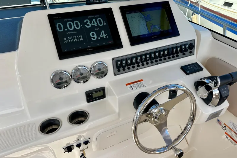 Slide: The Image of 2018 Wellcraft 290 Coastal helm with GPS displays, gauges, and steering wheel. - 21