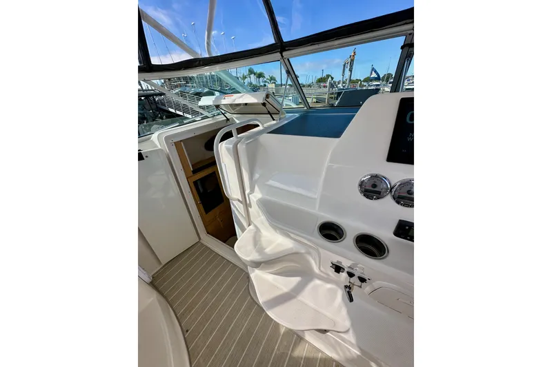 Slide: The Image of 2018 Wellcraft 290 Coastal boat interior with helm, gauges, and cabin entrance. - 24
