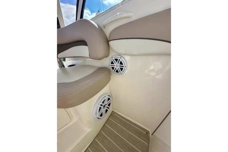Slide: The Image of Interior of 2018 Wellcraft 290 Coastal boat with beige seating and built-in speakers. - 25