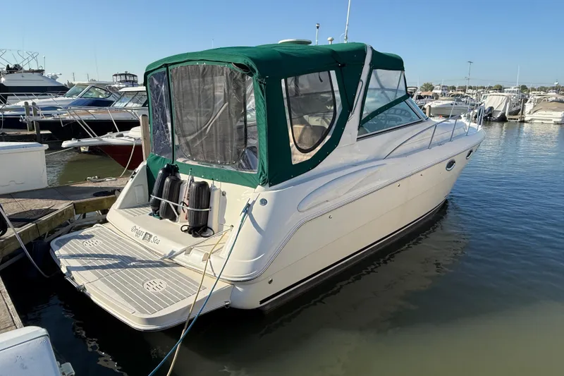 The Image of 2000 Monterey 322 Cruiser docked at marina, featuring green canopy and sleek design. - 0