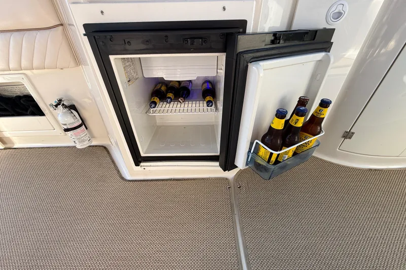 Slide: The Image of Mini fridge on 2000 Monterey 322 Cruiser with beer bottles inside and on the door. - 12