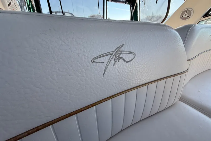 Slide: The Image of White leather seating with logo in a 2000 Monterey 322 Cruiser boat interior. - 17