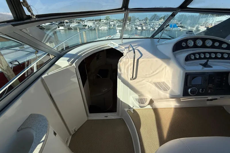 Slide: The Image of Interior view of 2000 Monterey 322 Cruiser boat cockpit with marina background. - 24
