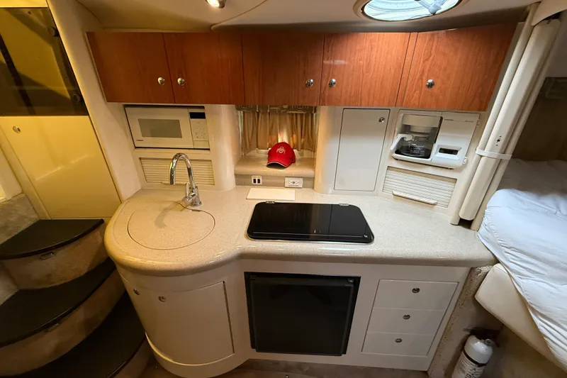 Slide: The Image of 2000 Monterey 322 Cruiser kitchen with sink, microwave, and stove in compact layout. - 26