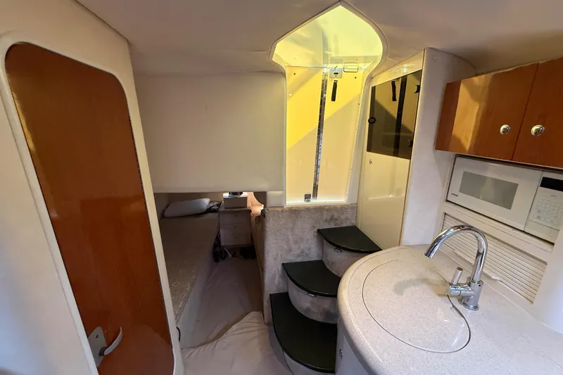 Slide: The Image of Interior of 2000 Monterey 322 Cruiser with kitchenette, stairs, and cozy sleeping area. - 33