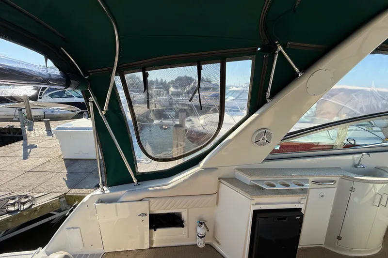 Slide: The Image of Interior view of 2000 Monterey 322 Cruiser boat with green canopy and dockside scenery. - 9