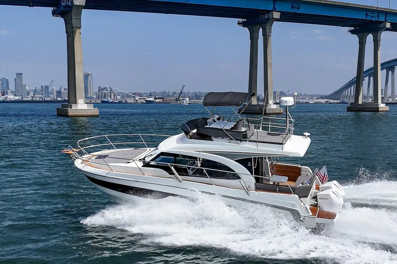 Slide: The Image of 2023 Beneteau Antares 11 Fly cruising under a bridge in a scenic waterway. - 14