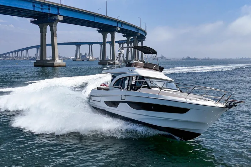 Slide: The Image of 2023 Beneteau Antares 11 Fly cruising under a bridge on open water. - 17
