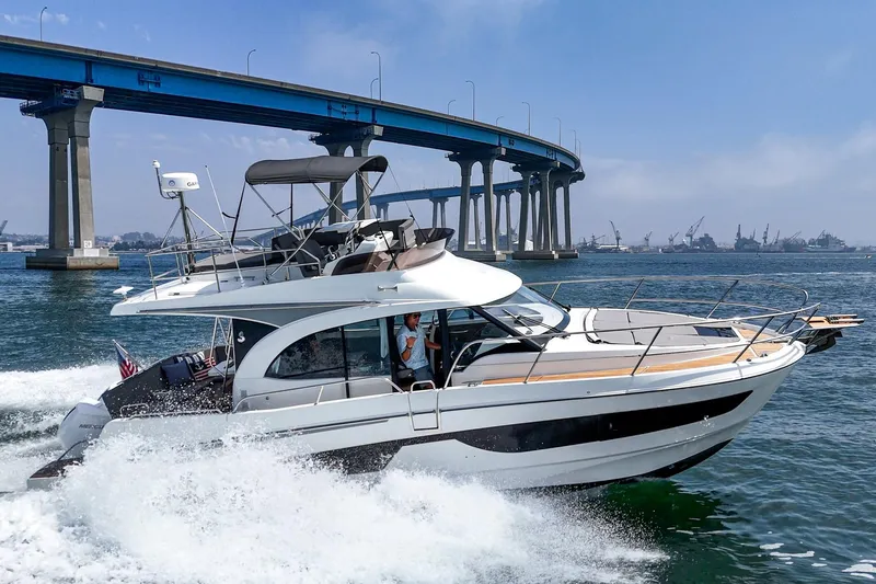 Slide: The Image of 2023 Beneteau Antares 11 Fly cruising under a bridge on a sunny day. - 23