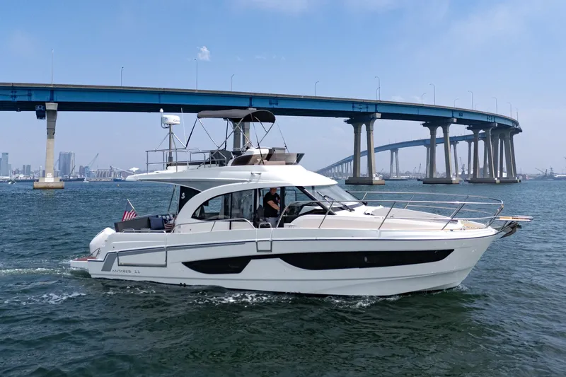 Slide: The Image of 2023 Beneteau Antares 11 Fly yacht cruising under a bridge on a sunny day. - 24
