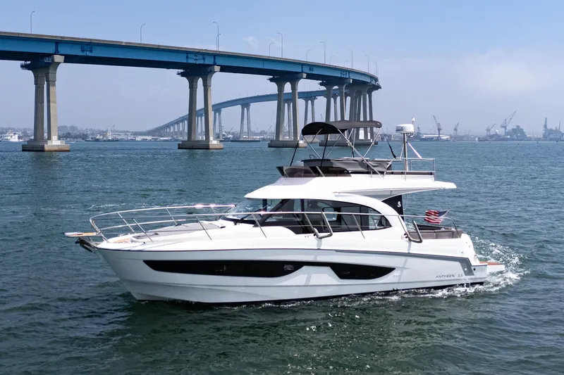 Slide: The Image of 2023 Beneteau Antares 11 Fly yacht cruising under a blue bridge on a sunny day. - 25