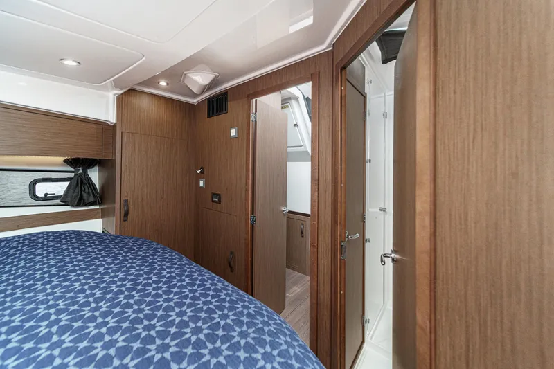 Slide: The Image of Interior of 2023 Beneteau Antares 11 Fly, featuring a cozy cabin with wood finishes. - 49