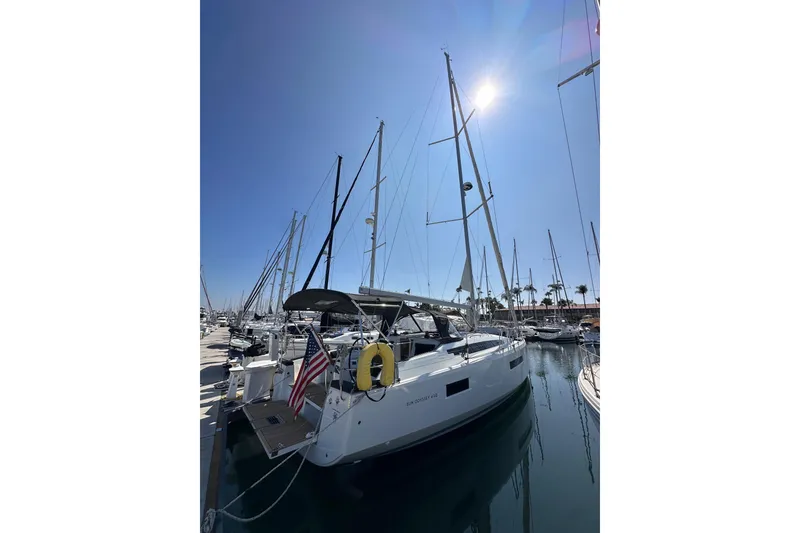 Slide: The Image of 2022 Jeanneau Sun Odyssey 410 sailboat docked in a sunny marina. - 2