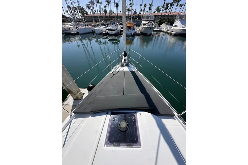 Slide: The Image of 2022 Jeanneau Sun Odyssey 410 sailboat bow view in marina with calm waters. - 24