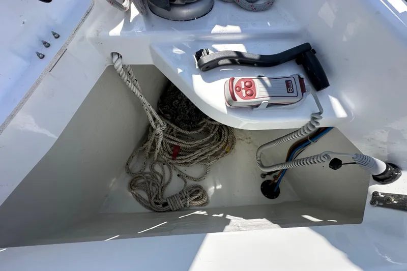 Slide: The Image of Storage compartment on Jeanneau Sun Odyssey 410 sailboat, featuring ropes and control device. - 25