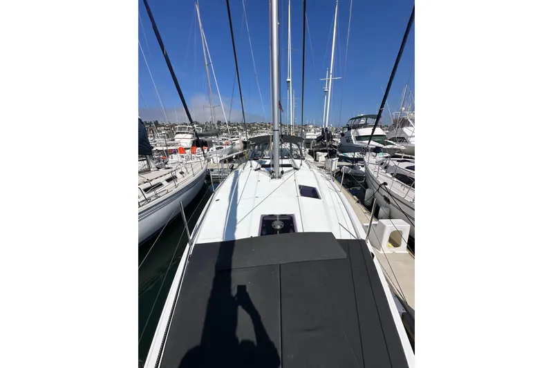 Slide: The Image of 2022 Jeanneau Sun Odyssey 410 sailboat docked at a marina, surrounded by other boats. - 28