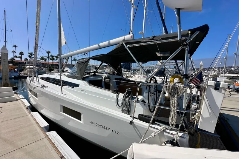 Slide: The Image of 2022 Jeanneau Sun Odyssey 410 sailboat docked at marina under clear blue sky. - 3