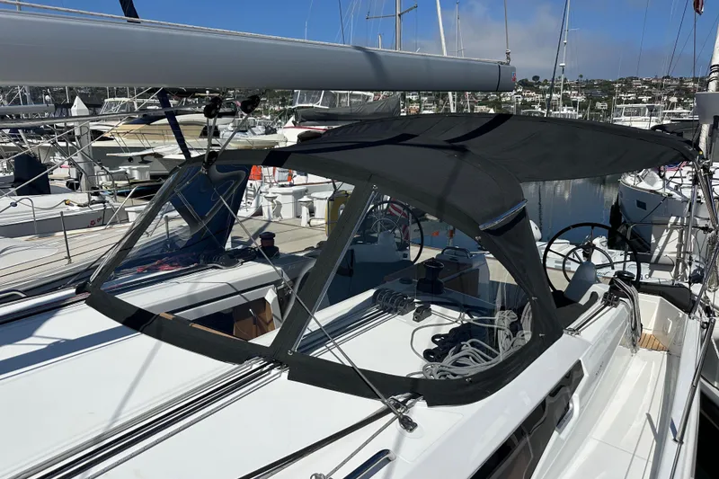 Slide: The Image of 2022 Jeanneau Sun Odyssey 410 sailboat docked at marina, featuring sleek design and black canopy. - 30