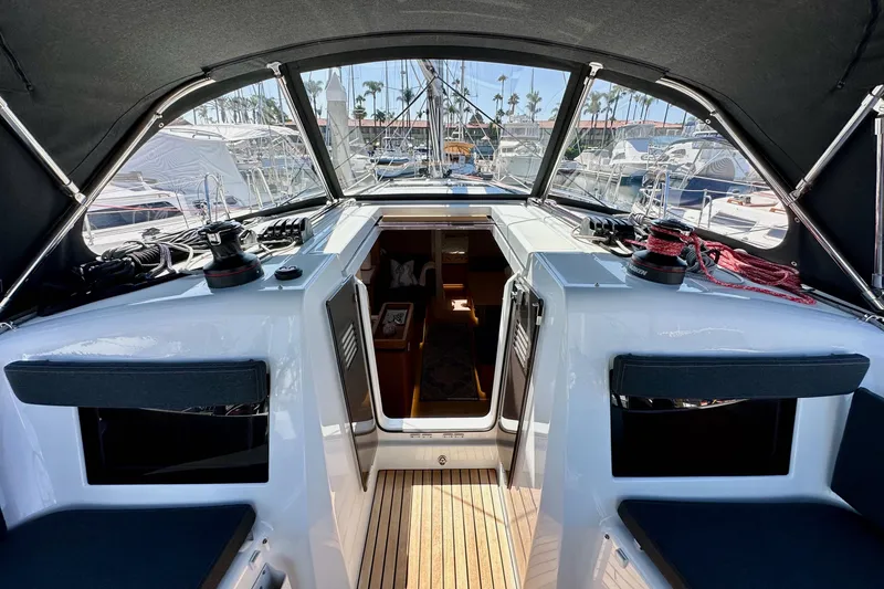 Slide: The Image of Cockpit view of 2022 Jeanneau Sun Odyssey 410 sailboat, featuring modern design and marina backdrop. - 33