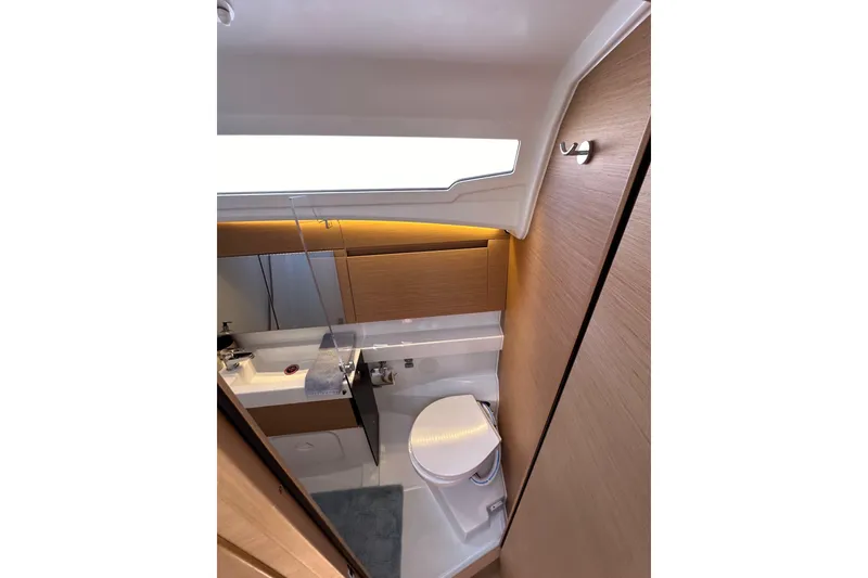 Slide: The Image of Modern bathroom interior of 2022 Jeanneau Sun Odyssey 410 yacht, featuring sleek design and wood accents. - 45