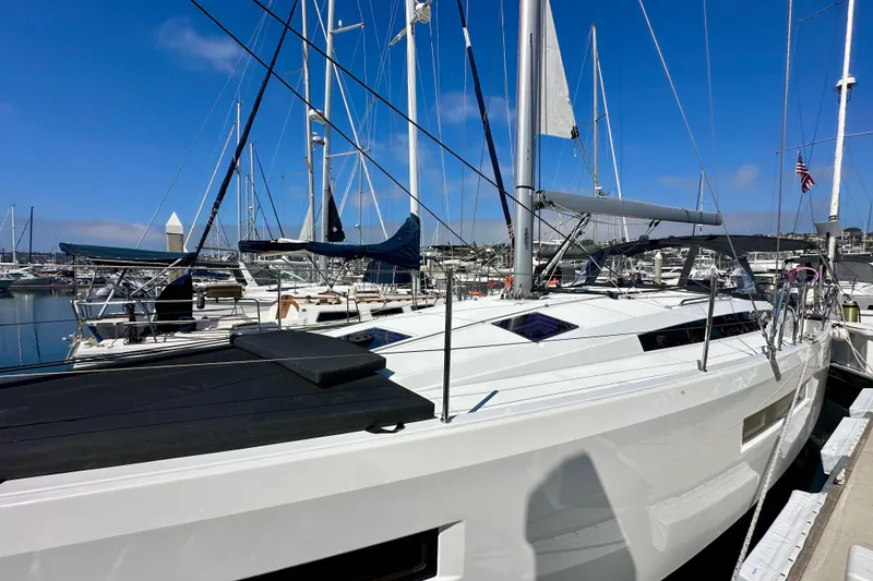 Slide: The Image of 2022 Jeanneau Sun Odyssey 410 sailboat docked in a marina under clear blue skies. - 5