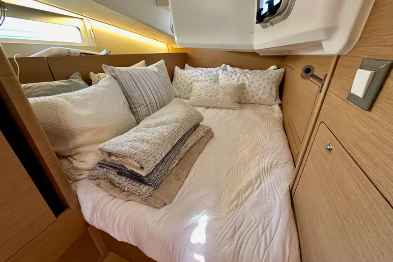 Slide: The Image of Cozy cabin interior of 2022 Jeanneau Sun Odyssey 410 with plush bedding and wooden accents. - 51