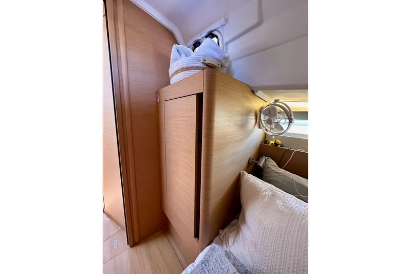 Slide: The Image of Interior cabin of 2022 Jeanneau Sun Odyssey 410 yacht, featuring wooden paneling and cozy bedding. - 52